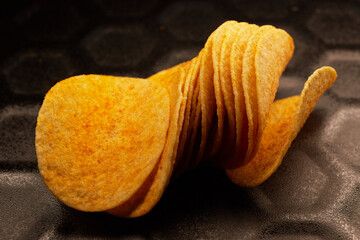 Close-up of several potato chips on a black baking tray