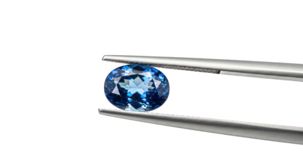 Blue gemstone in tweezers against the transparent background