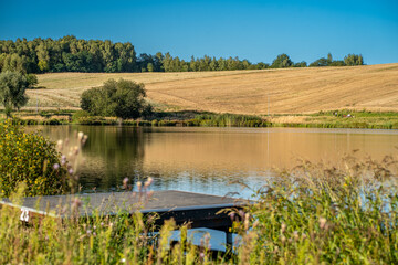Harvested Fields and Lakeside Pier in Sunny Countryside