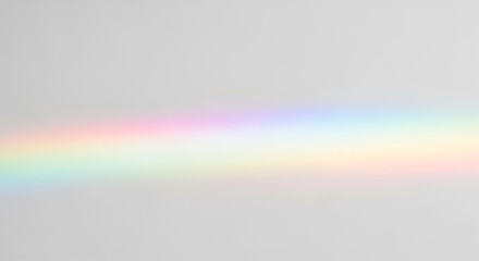 Horizontal rainbow light refraction spectrum on a plain gray background prism