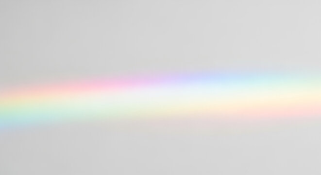 Horizontal rainbow light refraction spectrum on a plain gray background prism