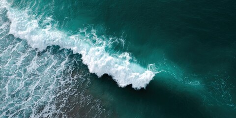 Aerial view of powerful ocean wave crashing on shoreline