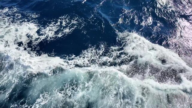 Dynamic ocean waves crashing powerfully on deep blue water surface creating splashing patterns