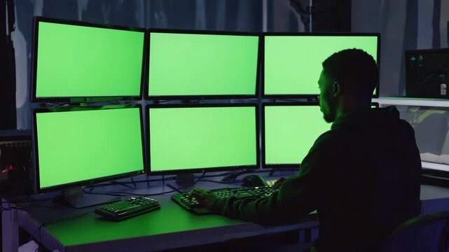Multiple screens display green background in tech workspace