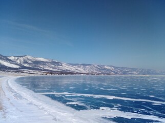Winter landscape of frozen Lake Baikal under clear blue sky