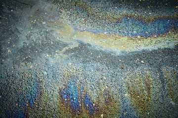 Oil Slick Reflects Colors on Wet Pavement After Rain in Urban Setting During a Cloudy Afternoon.