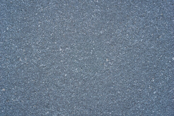 dark gray asphalt or concrete surface texture with fine granular aggregate, detailed road or pavement background, concept of construction, transportation, building material