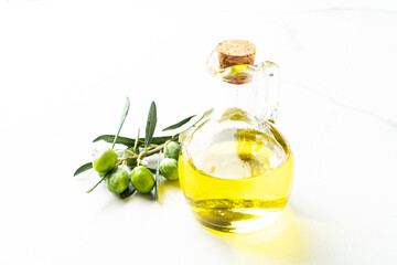Olive oil in the bottle at white table.