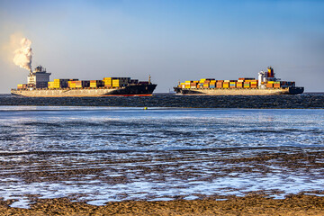 Germany, Elbe River Estuary. Two container ships passing by at the mouth of the Elbe River near Cuxhaven