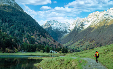 A hiker walks along Lake Estaing, France