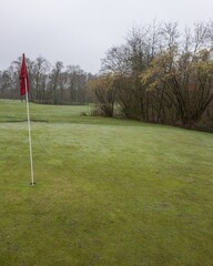 Obraz premium Serene golf course green with red flag