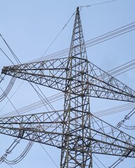 Electricity pylon towering against clear blue sky, carrying power lines