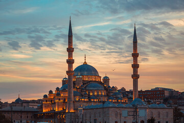 Fototapeta premium The illuminated New Valide Sultan Mosque on the shore of the Golden Horn.
