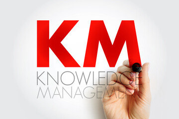 KM Knowledge Management acronym written by hand. Business and organizational learning concept representing information sharing, strategy, and innovation within a company