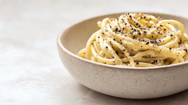 A cacio e pepe served in matte ceramic bowl, minimalist composition, off-white background