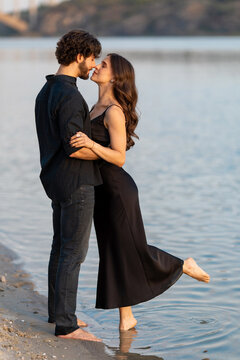 Romantic couple standing in water near beach