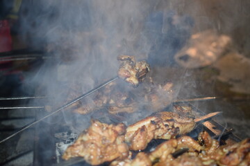 Grilling Delights: Sizzling skewers of marinated chicken cooked over an open fire, a smoky, tantalizing scene with the promise of deliciousness.