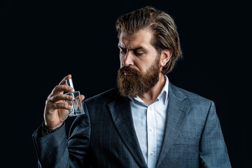 Masculine perfume. Man perfume, fragrance. Male fragrance and perfumery, cosmetics. Man holding up bottle of perfumery. Cologne bottle