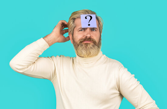 Thinking man with question mark on blue background. Man with question mark on forehead. Paper notes with question marks. Beard man question mark in head, solution problems