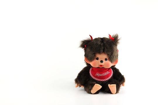 a popular classic doll toy , Monchichi or Monchhichi , Japanese cute monkey fur doll display on white table with white wall background in souvenir tourist shop in Japan