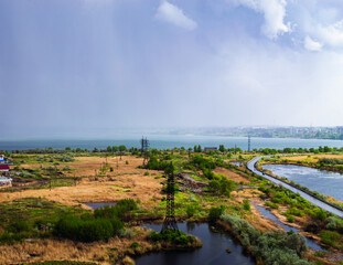 Heavy rainfall over countryside near lake