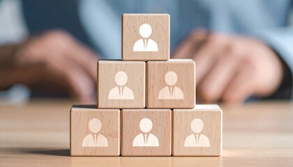 Pyramid of wooden blocks with suit icons, person in blue shirt arranging top block.