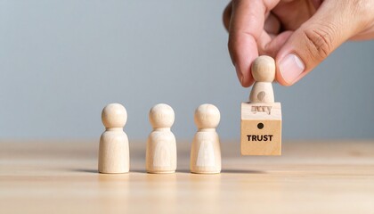 Four wooden figurines on wood surface, one lifted onto “TRUST” block with keyhole symbol.