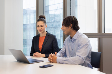 Two young professionals working in a corporate office