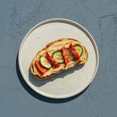 Wholesome hummus toast topped with fresh cucumber, red bell pepper, and sesame seeds on a plate
