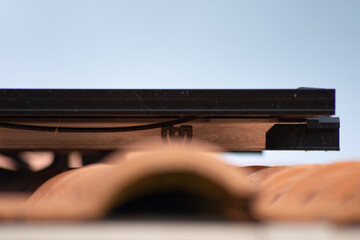 Gros plan sur la tranche d'un panneau solaire posé sur des tuiles