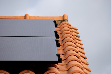 Gros plan sur deux panneaux solaires posés sur tuiles en 2025, format paysage
