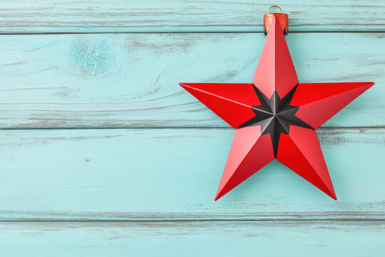 Christmas minimal red star ornament hanging on light blue wooden background creates festive and modern holiday atmosphere