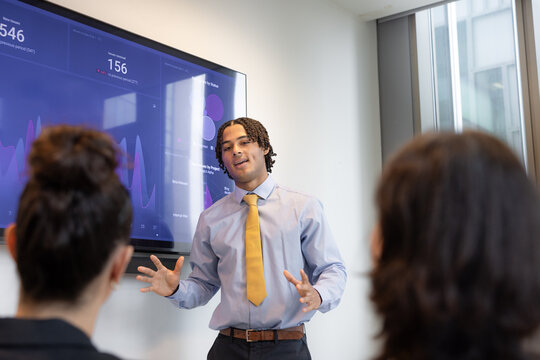 New employee presenting to coworkers in a corporate office
