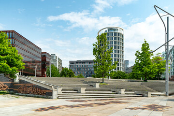 Modern park area with curved metal sculpture and glass architecture in Hafencity, Hamburg