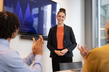 Team Applauds young employee at Successful Business Presentation