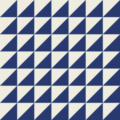 Seamless geometric pattern with diagonally into a dark blue triangle and an off-white triangle.