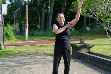 Woman Stretching Arm in Park for Health and Fitness