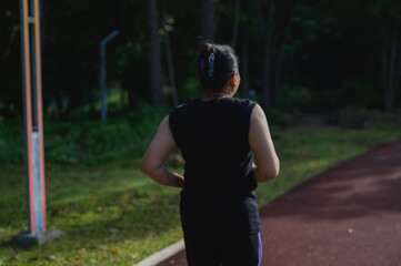 Woman Running Outdoors on Green Path in Sunny Park