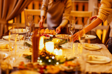 Young women are preparing a Christmas lunch. Friends chat and set the festive table