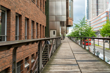Wooden pedestrian walkway surrounded by modern and historic architecture in Hamburg.