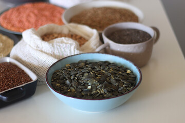 Bowls and bags full of various healthy grains and legumes. Selective focus.