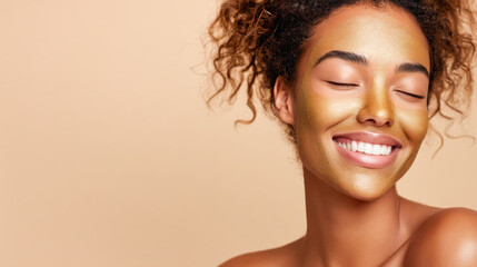 Smiling woman with golden facial mask, showcasing radiant skin and natural beauty against a soft beige background, embodying self-care and relaxation
