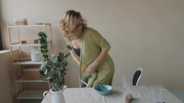 Woman preparing healthy breakfast while using smartphone