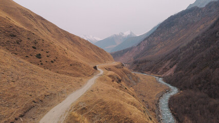 Vast Golden Mountain Landscape with Distant Snow-Capped Peaks