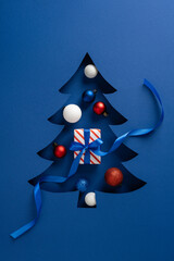 A vertical festive blue card features a stylized Christmas tree cutout with colorful ornaments, a...