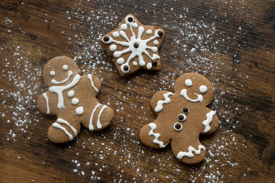 Festive Gingerbread Cookies with Icing on Rustic Wood Background