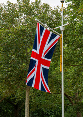 Union Jack Flag Waving Amidst Lush Green Trees in London