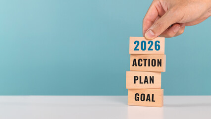 2026 GOAL PLAN ACTION. start up business. new year. Put last piece of wooden cube with the letters...
