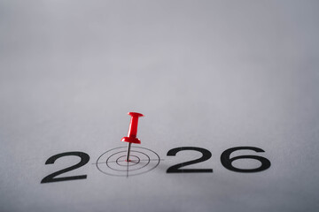 A red pushpin marking a target symbol within the year 2026, representing goal setting, planning, deadlines, strategic focus, and preparation for future milestones and important objectives ahead.