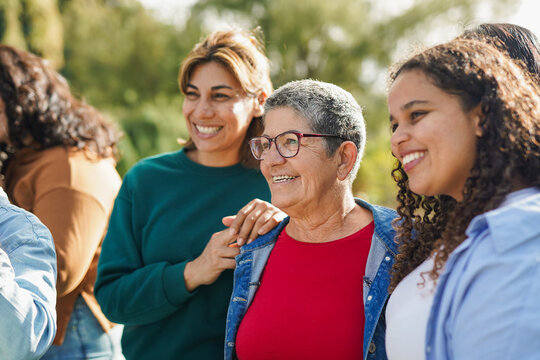 Group of multiracial women with different age meet each other at city park - Multi generational female circle outdoor - Focus on senior woman face